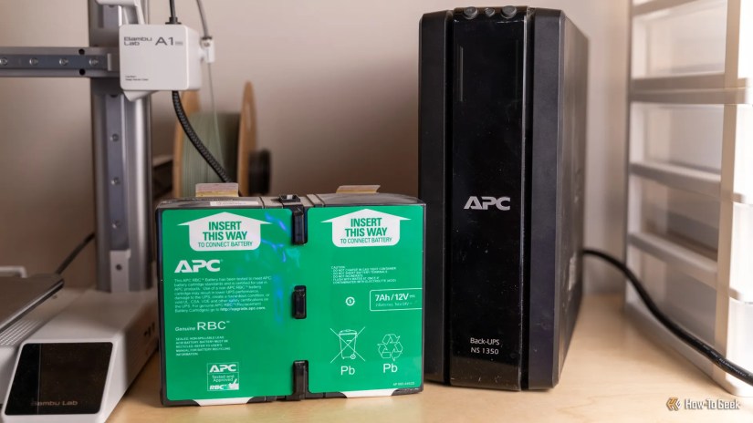 The APC BackUPS NS1350 UPS with an old battery sitting next to it.