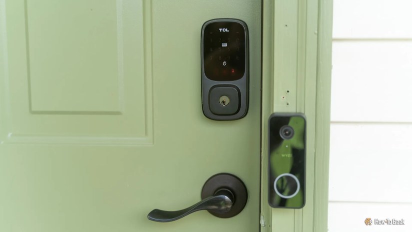 The TCL D1 Pro palm vein smart lock installed on a green door.
