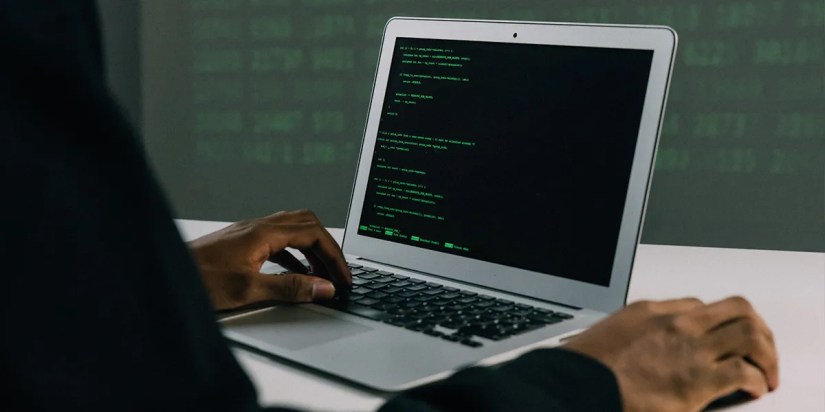 Hacker on MacBook hacking WiFi