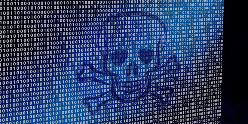 skull illuminated on screen against binary code