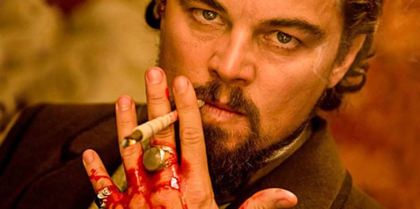 Leonardo DiCaprio as Calvin Candie smoking a cigarette while his hand bleeds inside his mansion in Django Unchained