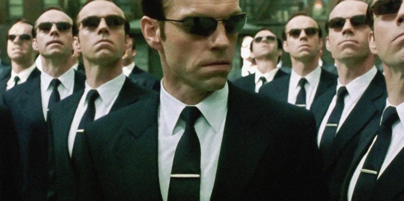 A number of Agent Smiths (all played by Hugo Weaving) standing together in The Matrix.