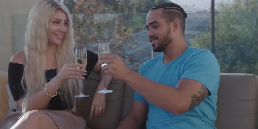 90 Day FIance&rsquo;s Sophie Sierra and Rob Warne drinking champagne on a couch