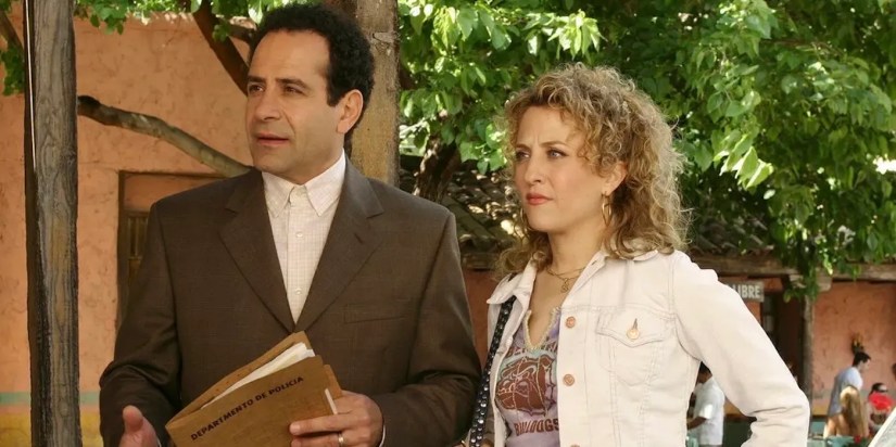 Tony Shalhoub as Adrian Monk and Bitty Schram as Sharona Fleming are standing outside next to one another.