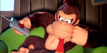 Donkey Kong sitting on a couch holding a remote with big red button