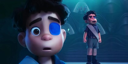 A composite image of Elio looking on in shock in front of Elio standing with his hands firmly at his side onstage in Elio