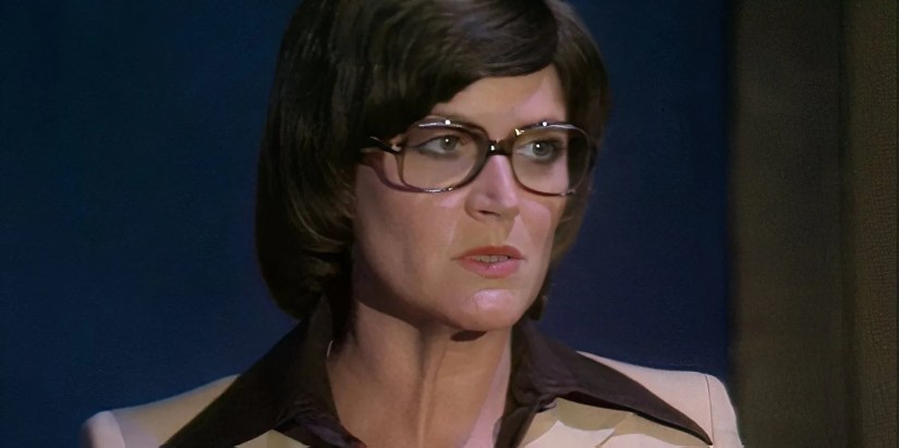 Patricia Maynard as Hilda Winters in front of a red curtain in the Doctor Who serial Robot.