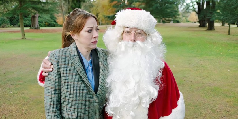 Diane Morgan as Philomena Cunk frowning at Santa, whose arm is around her, in Cunk on Christmas.