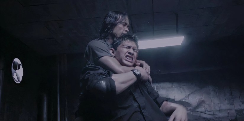 Iko Uwais getting choked out by an attacker in The Raid
