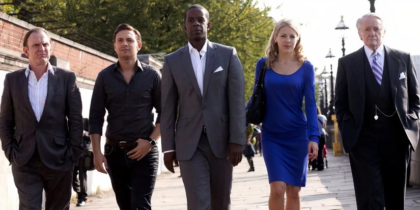 Ash, Sean, Mickey, Emma, and Albert walking by the River Thames in smart clothing in Hustle.