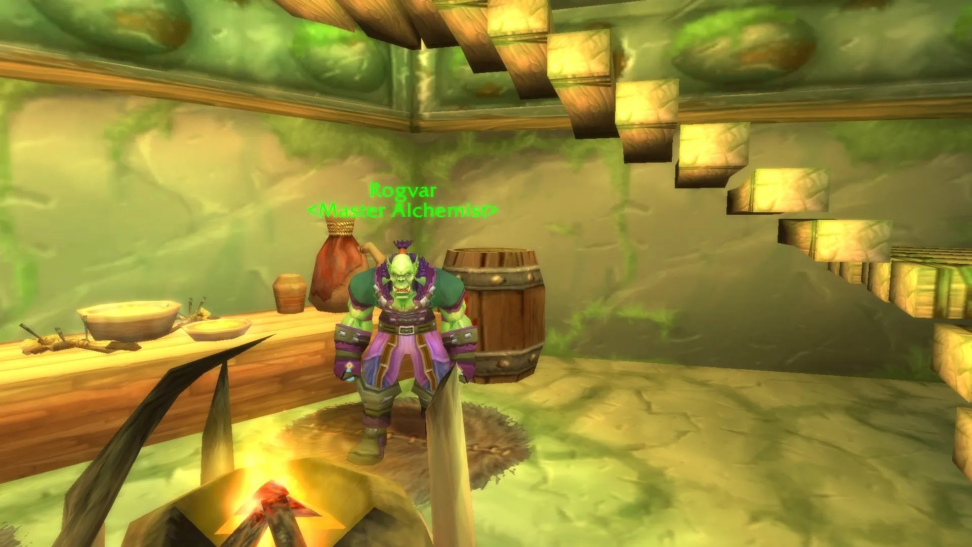 Rogvar, the Horde master alchemist standing at his work table in a building in the town of Stonard