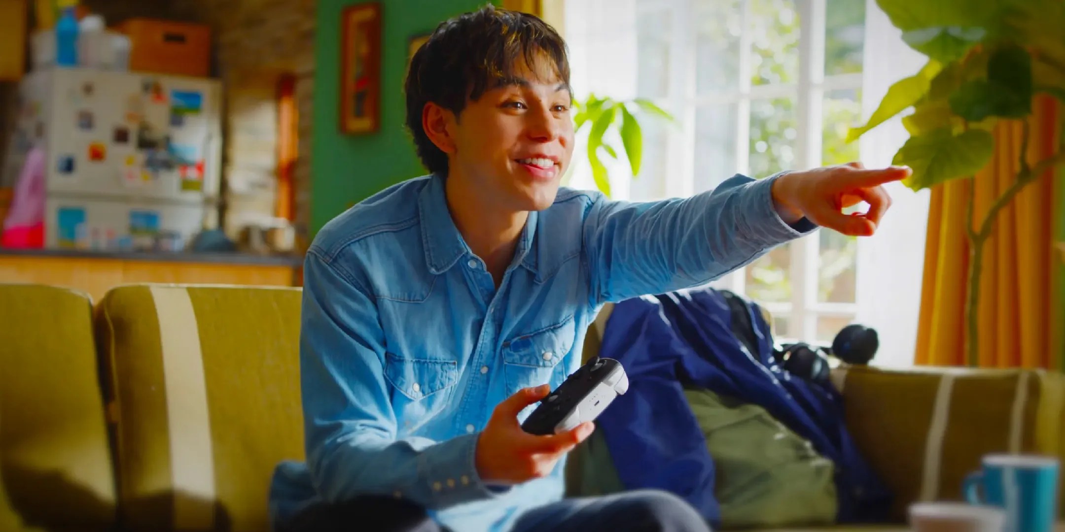 Switch 2 player pointing at the screen while holding a Pro controller.