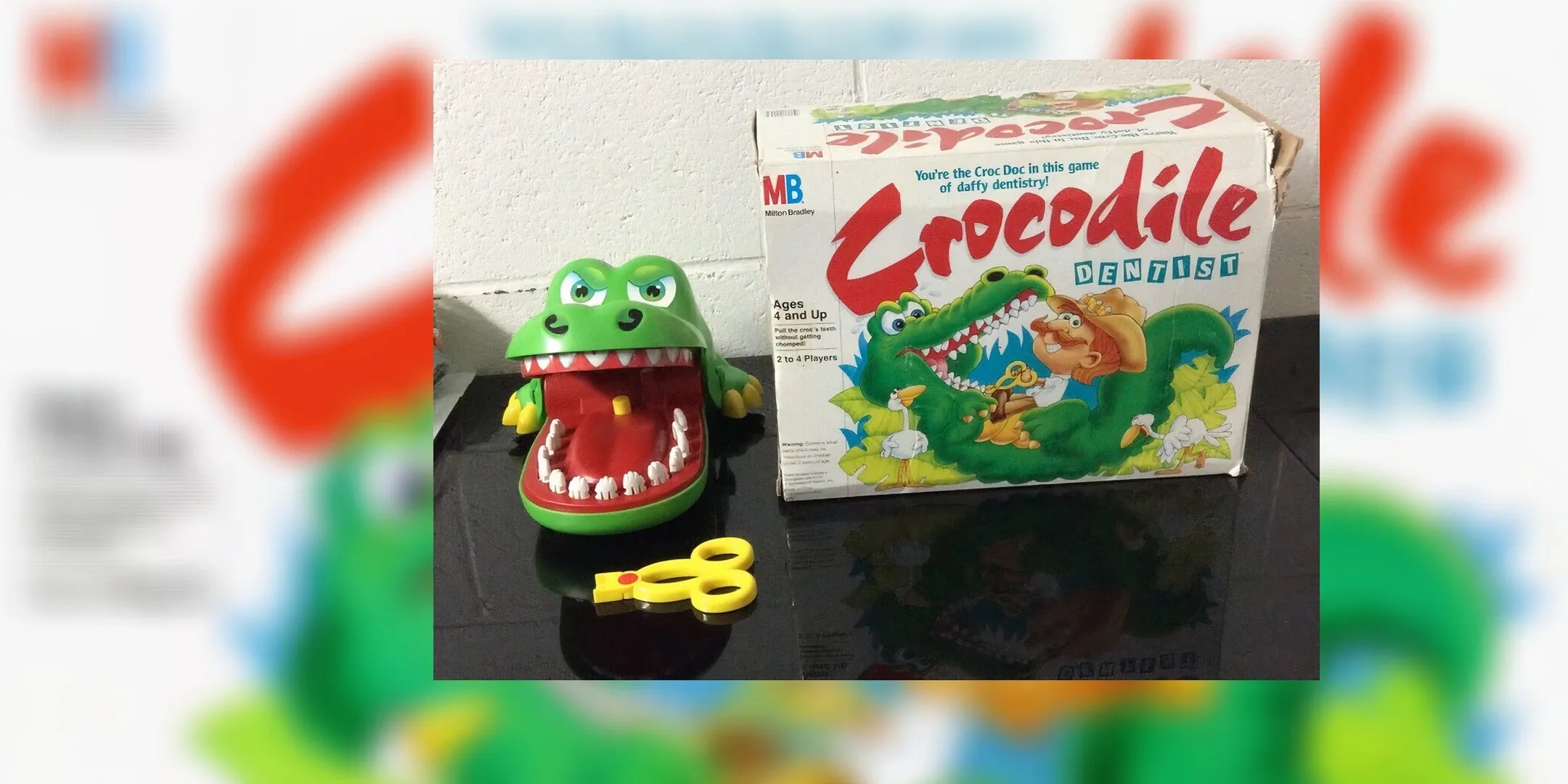 Crocodile Dentist complete set with crocodile and tooth puller on the left, while the box is on the right.