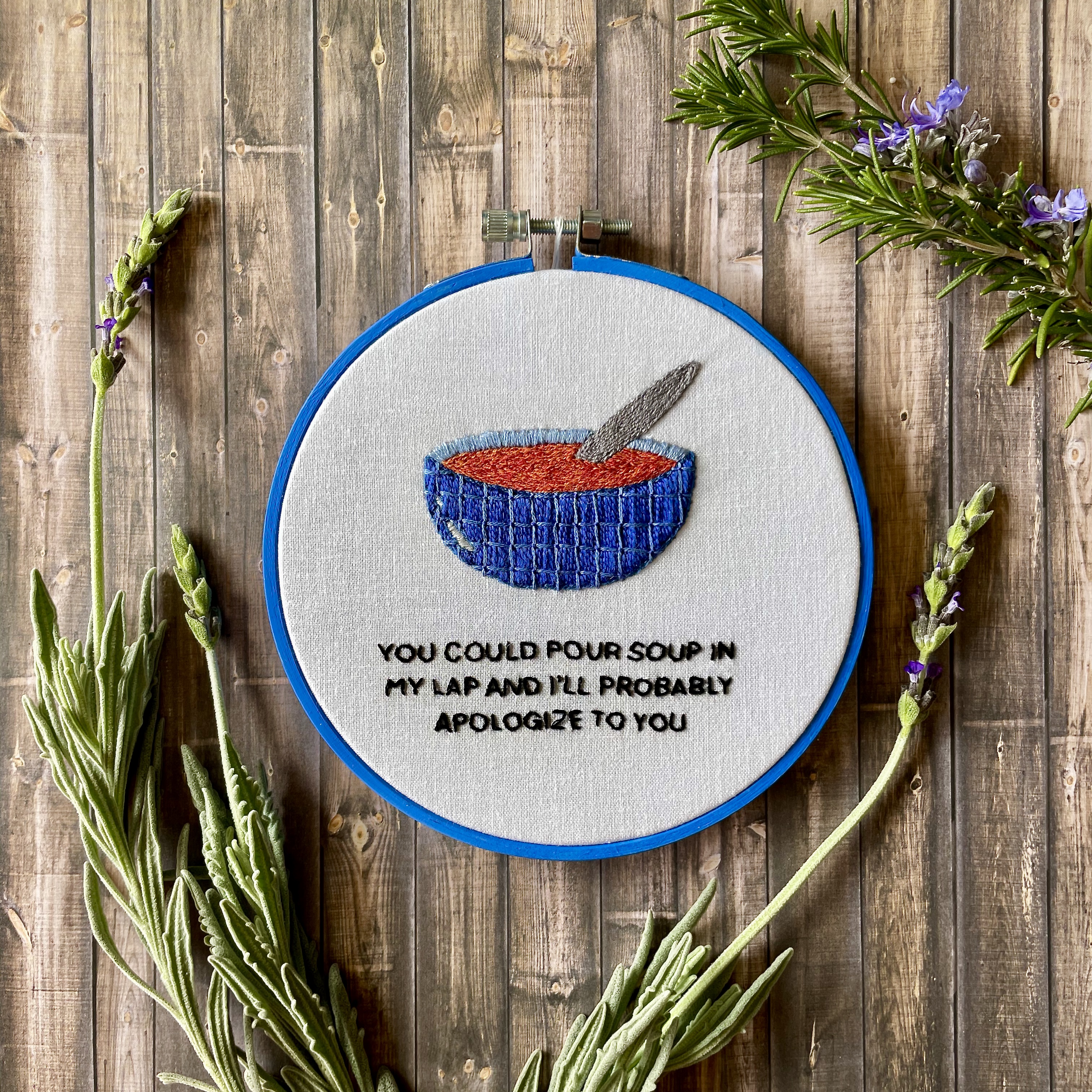 john mulaney embroidery framed in a blue bamboo hoop.