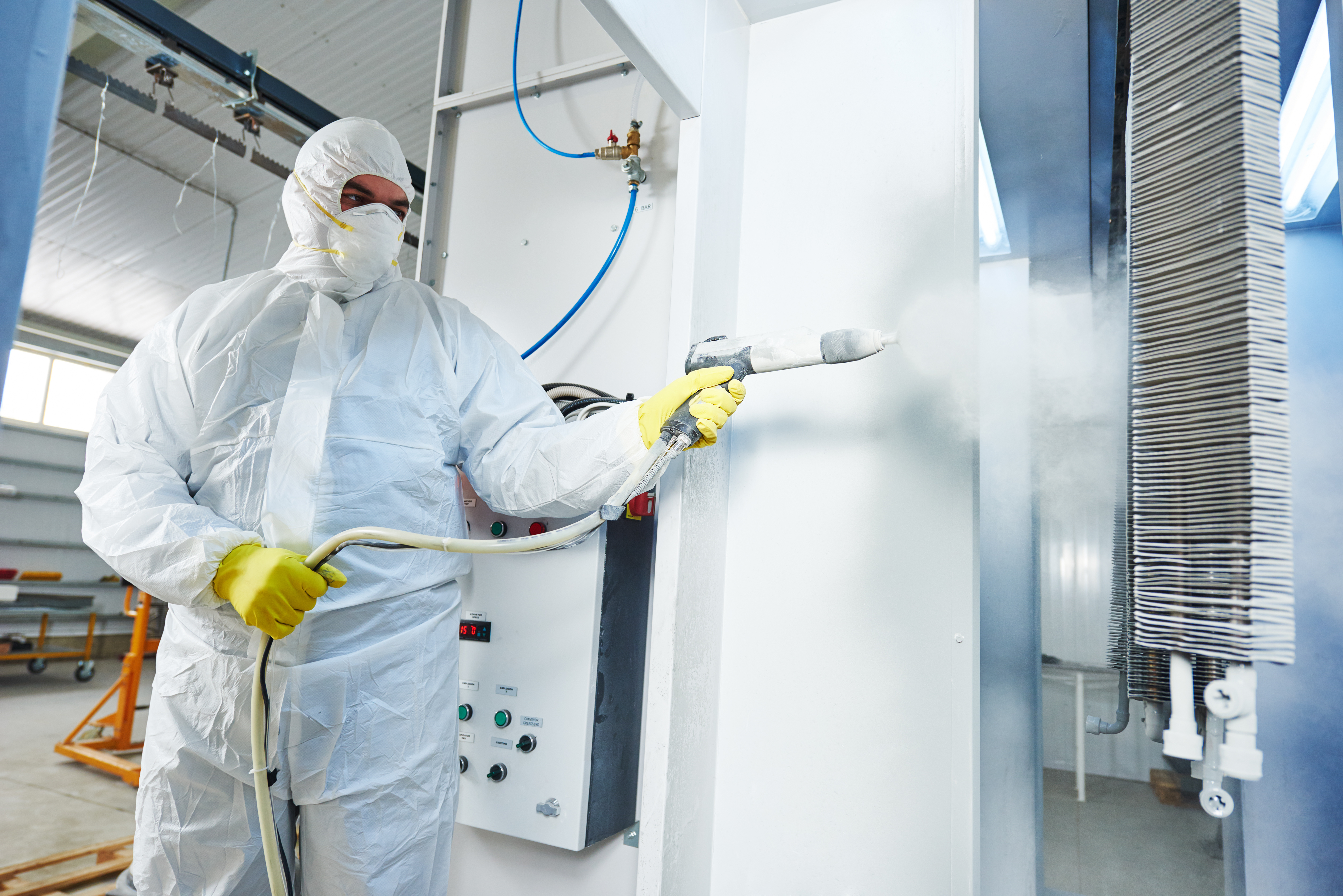 industrial metal coating. Man in protective suit, wearing a gas