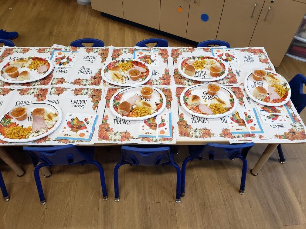 Thanksgiving plates are laid out on a long table for CHILD Center students to enjoy