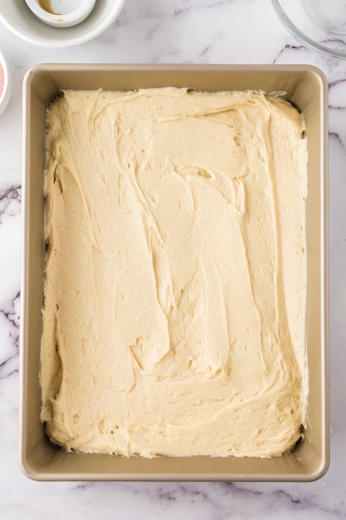 A baking pan with a raspberry sheet cake in the middle.