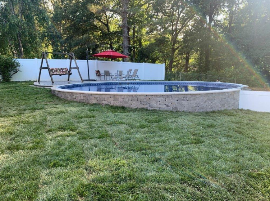 An aboveground pool in a sloped backyard Swim Tutors