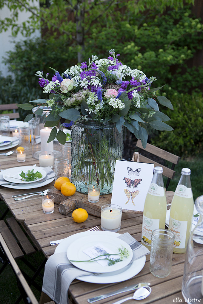 This tablescape is country chic with a gorgeous purple flower centerpiece and lavender table settings
