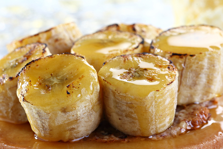 This bananas foster is topped with sweet syrup and fresh fruit.
