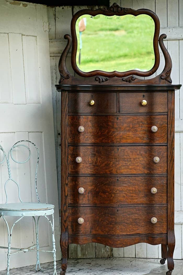 This dark stained antique dresser pairs well with the farmhouse theme.