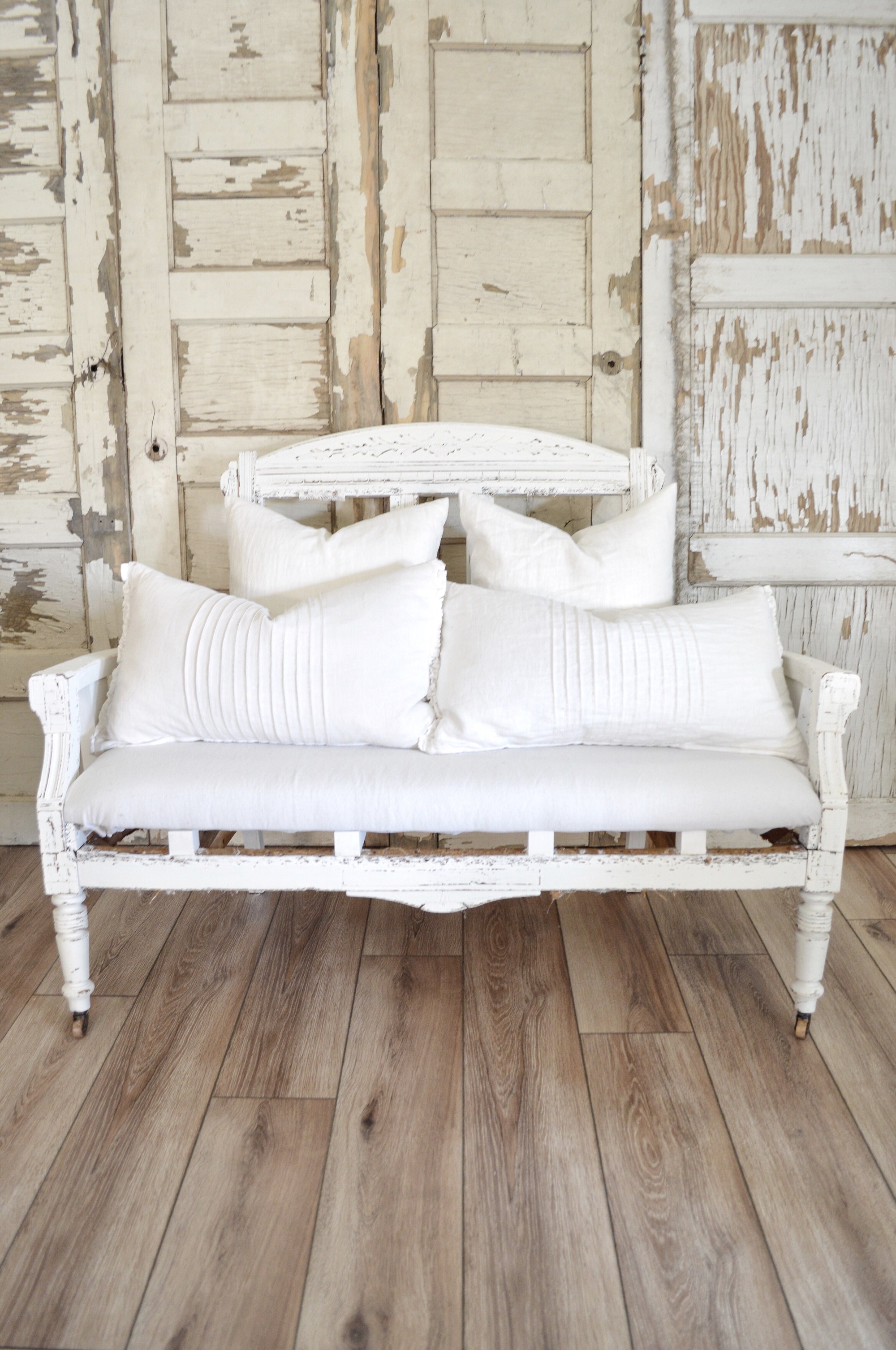 This incredible farmhouse style porch is complete with this white Settee bench