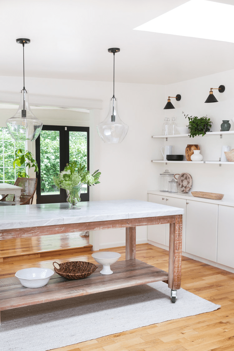 This minimal kitchen has gorgeous farmhouse elements like the barnhouse and marble island and floating shelves