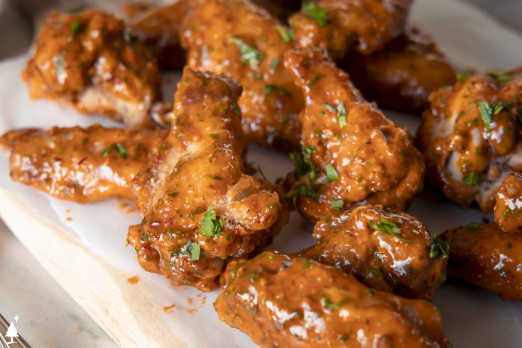 These chipotle lime chicken wings are everything you love about classic wings, with an unexpected sucker-punch of southwestern flavors. #ketochipotlelimechickenwings #lowcarbchipotlelimechickenwings closer view of chipotle wings on a platter