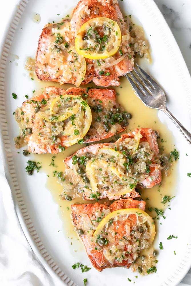 Tender, perfectly cooked fish, and a luxurious sauce spiked with capers, this salmon piccata makes an easy dinner feel extra elegant. #salmonpiccata #lowcarbsalmonpiccata closer view of salmon piccata healthy