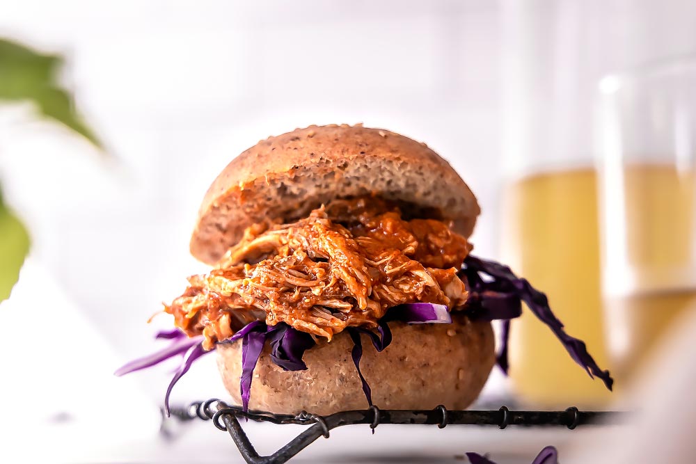 *NEW* This smoky, juicy, and succulently tender keto pulled pork is jam-packed with powerful flavors from the homemade (and sugar-free!) BBQ sauce! #lowcarbpulledpork #ketopulledpork keto pulled pork smoker on fluffy buns