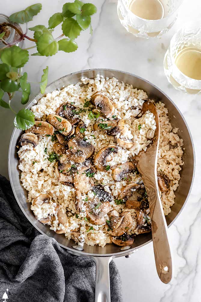 Mushrooms, garlic, and shallots bring the flavor in this buttery, creamy cauliflower risotto for a side dish you'll want to eat as your main! #cauliflowerrisotto #lowcarbcauliflowerrisotto top view of cheesy cauliflower risotto