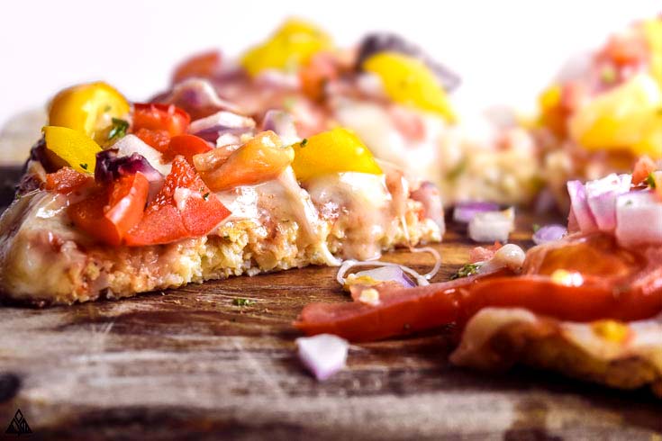 Keto cauliflower pizza crust is a slightly crispy, totally delicious low carb pizza dough with all the amazing health benefits of cauliflower! #cauliflowerpizzacrust #lowcarbcauliflowerpizzacrust side view of cauliflower pizza