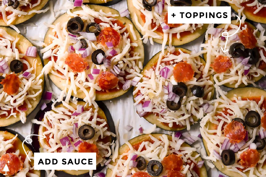 The perfect low carb pizza is begging to be covered in your favorite toppings--allow your keto eggplant pizza to soak up some saucy goodness. #lowcarbeggplantpizza #eggplantpizza slices of eggplant with sauce and toppings on a baking sheet