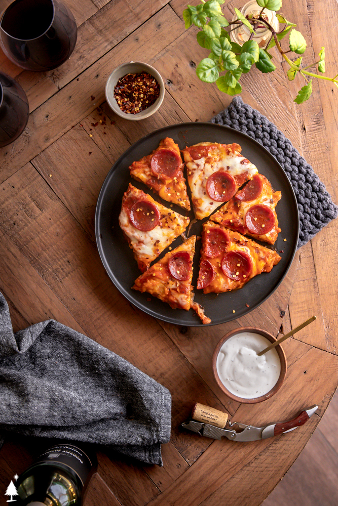 Get your pizza pizzazz on, with this juicy, flavor packed chicken crust pizza. It's an easy to make keto pizza you can EAT WITH YOUR HANDS! #ketochickencrustpizza #lowcarbchickencrustpizza top view of chicken pizza crust on a platter