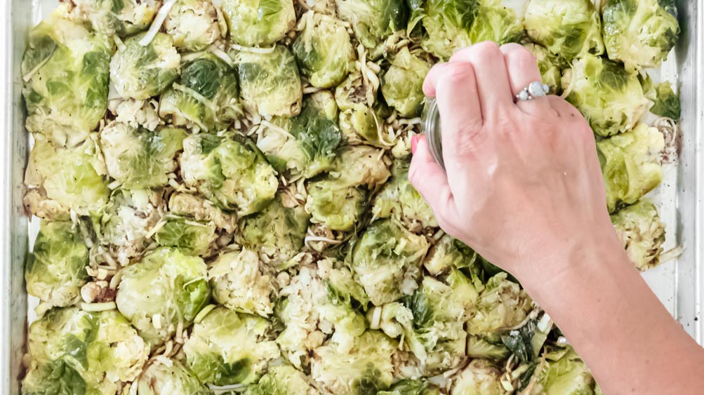 *NEW* Crispy baked parmesan cover these smashed brussels sprouts, for a tasty side dish that'll forever change the way you feel about this veggie! #smashedbrusselssprouts #lowcarbsmashedbrusselssprouts top view of smashed brussels sprouts with parmesan