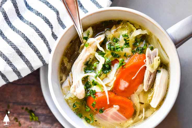 The easiest of keto chicken soup recipe - extra herbs, and a handful of parmesan make this chicken noodle soup extra special! top view of keto chicken soup with cabbage