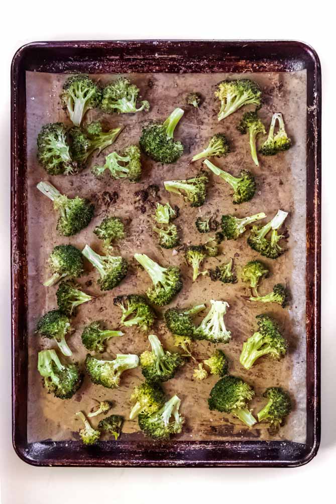 *NEW* High heat, a good olive oil, and evenly sliced florets are all you need for perfect oven roasted broccoli with crisp edges and soft interior! #roastedbroccoli #lowcarbroastedbroccoli top view of roasted broccoli recipe
