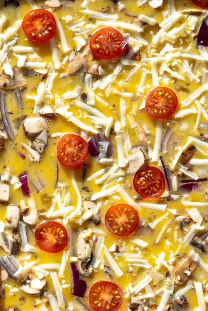 sheet pan eggs in oven with cheese on top