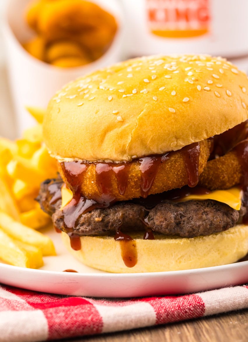 copycat burger king rodeo burger on a small white plate with french fries on the side