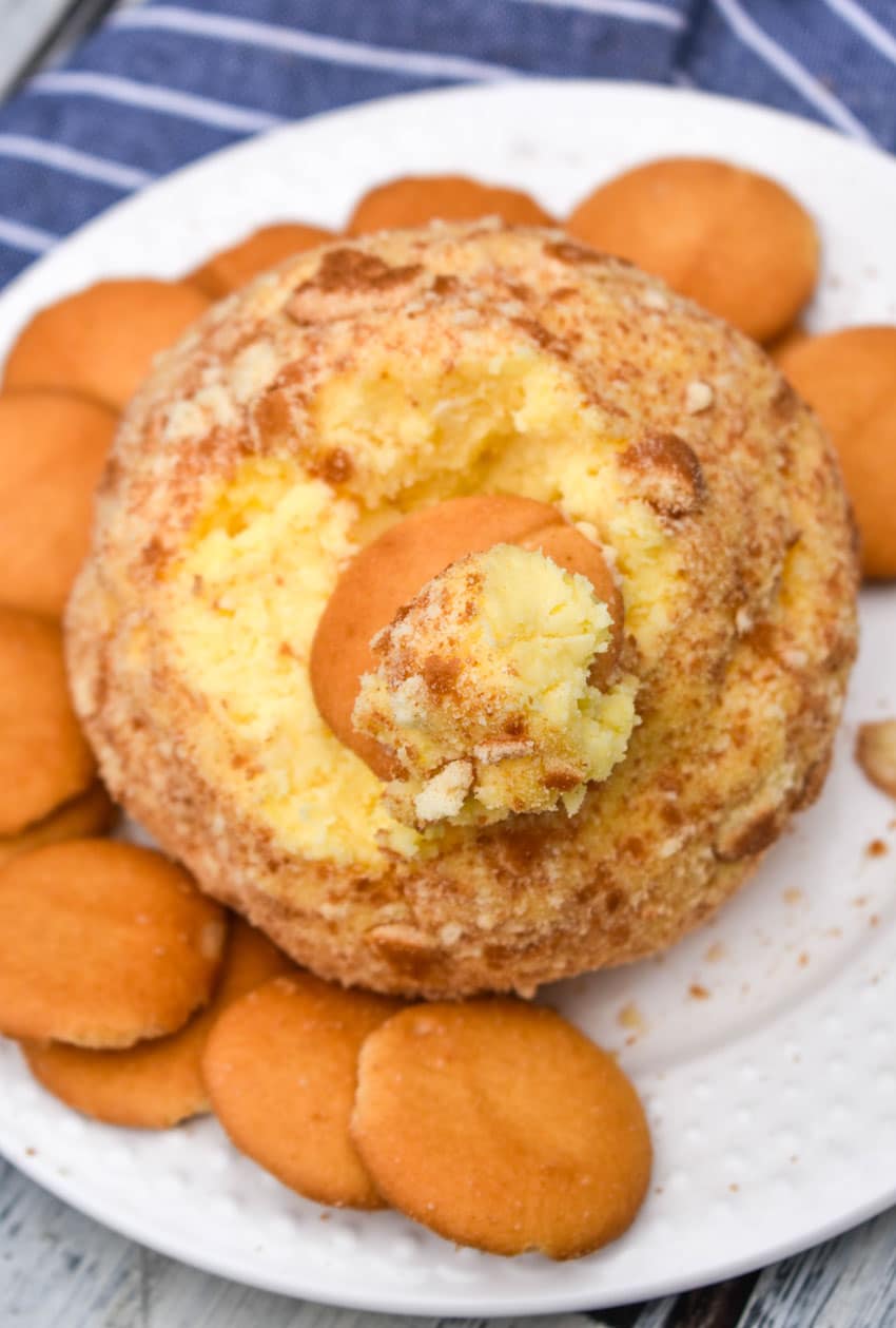 a banana pudding cheese ball surrounded by nilla wafers on a small white plate