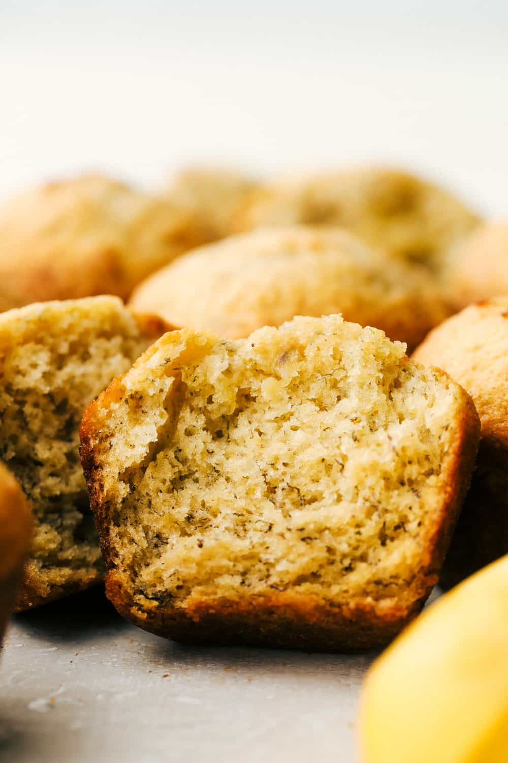Banana Muffins are a great way to use mushy bananas. Quick and easy you can be eating these in no time, perfect for snacks or breakfast! Up close shot of half a muffin.