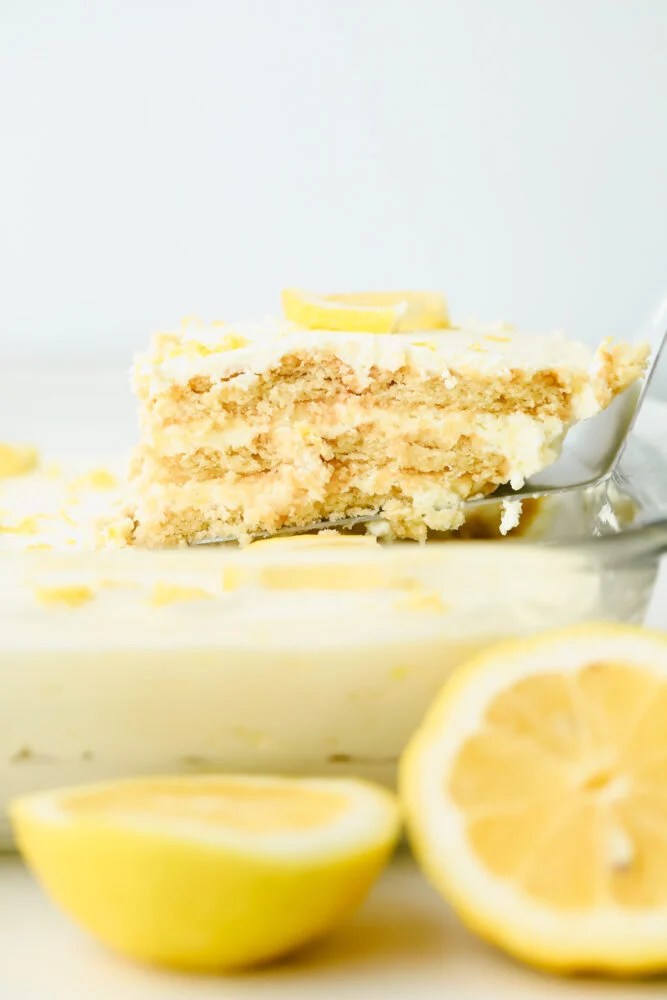 Layers of buttery shortbread and lemon cream come together in this scrumptious no-bake summer dessert! Not only is this recipe beyond easy, but has the perfect balance of tart and sweet flavors! Taking a piece of Lemon Icebox Cake.