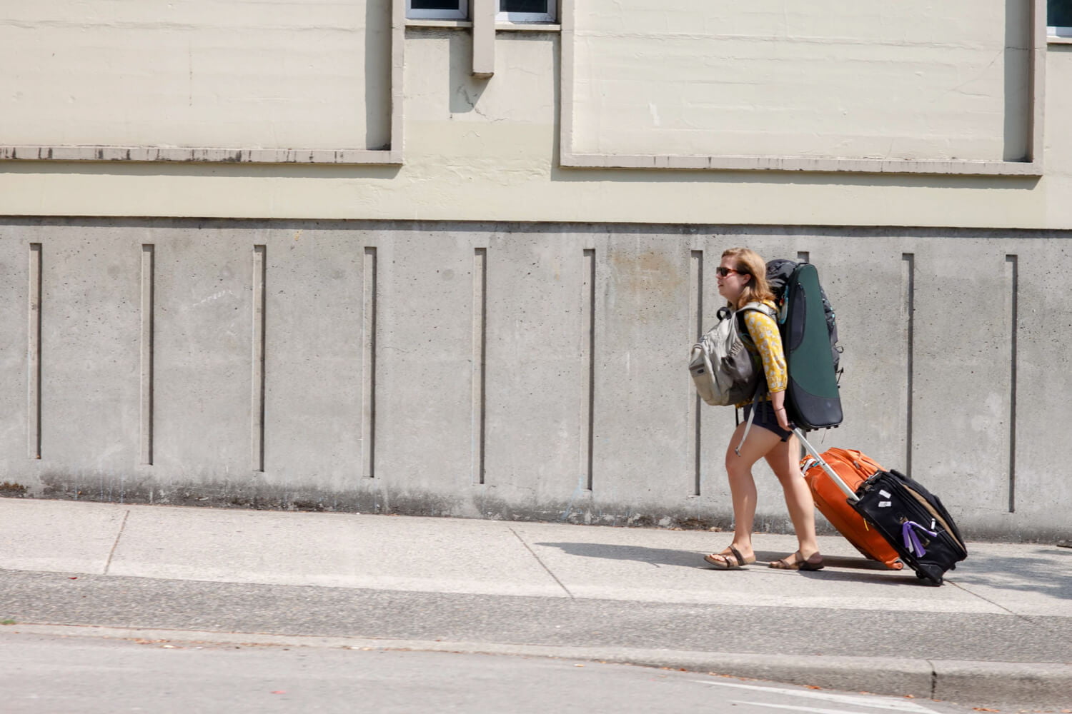 Lady walking on street with tons of bags.