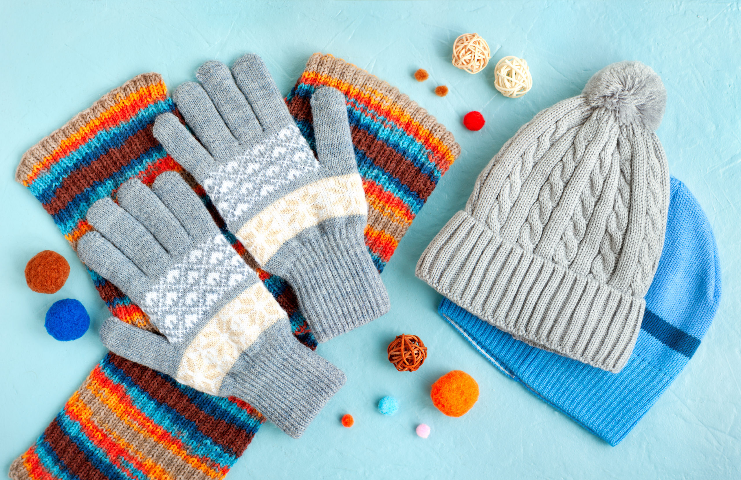 Hats, gloves and a scarf on a textured background. Warm clothes for