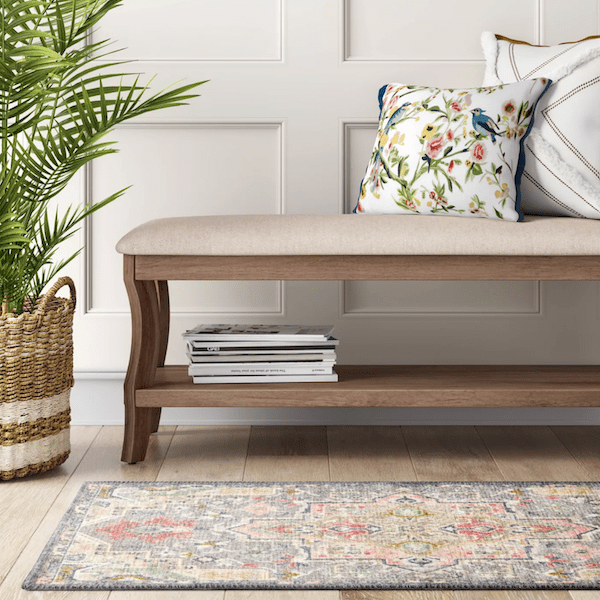 colorful accent rug in front of bench