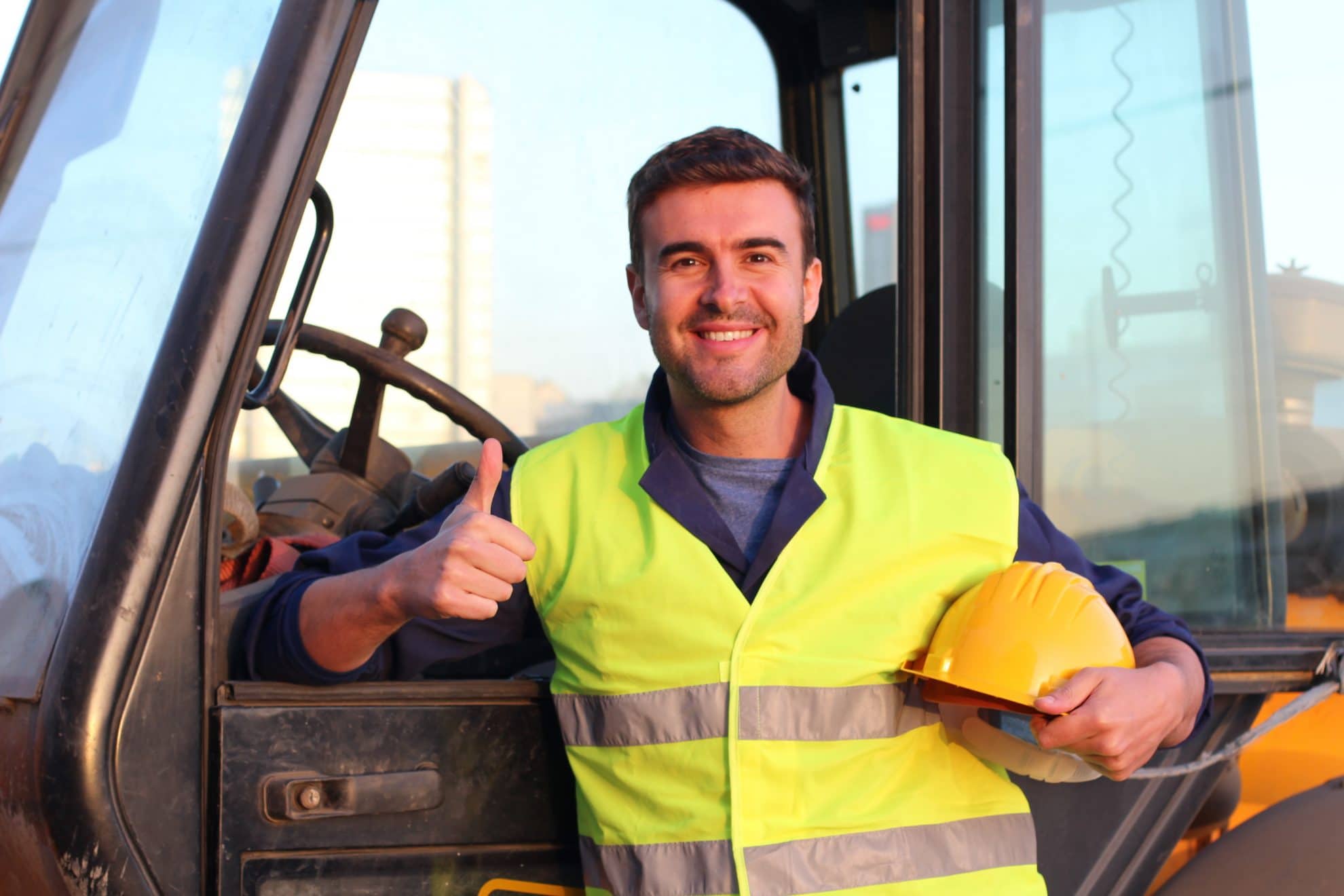 Construction driver with excavator on the background