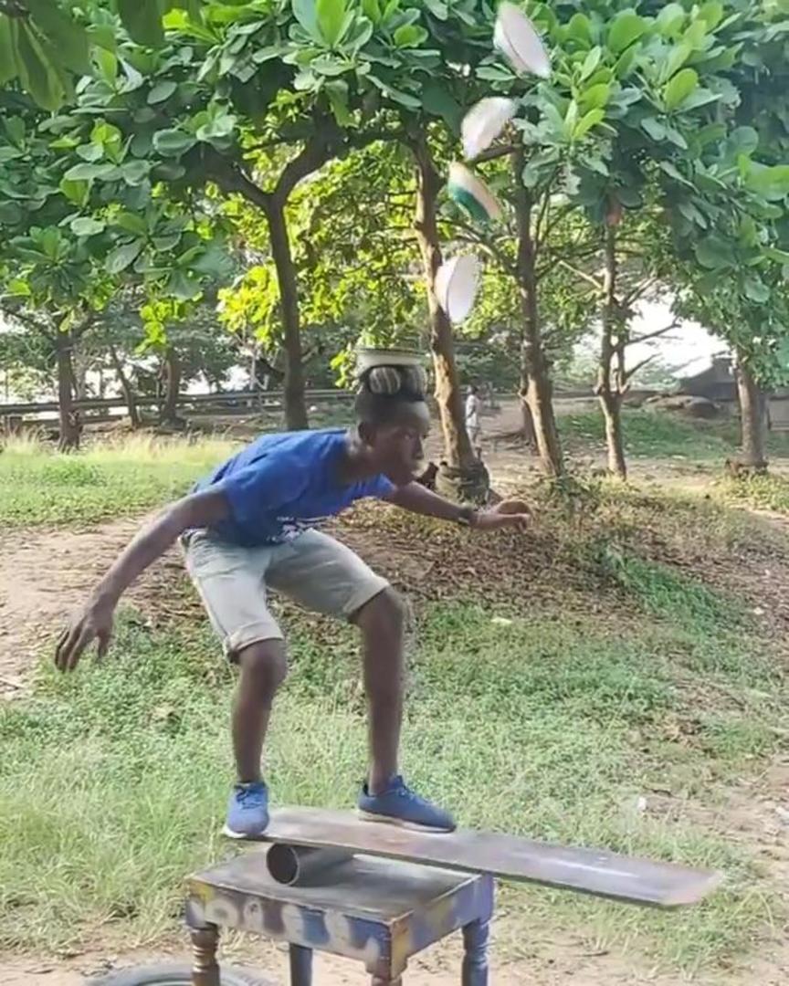 Boys Flip And Balance Multiple Bowls On Head While Standing On Balance