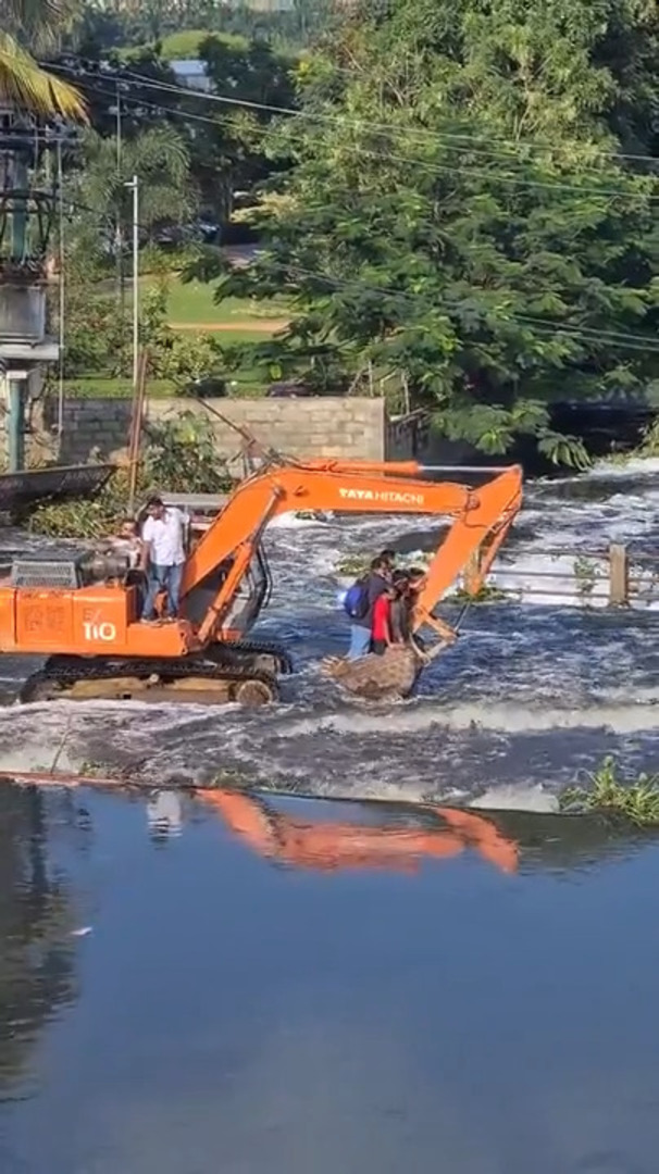 Group of People Gets Ride on Excavator Through Flooded Area in