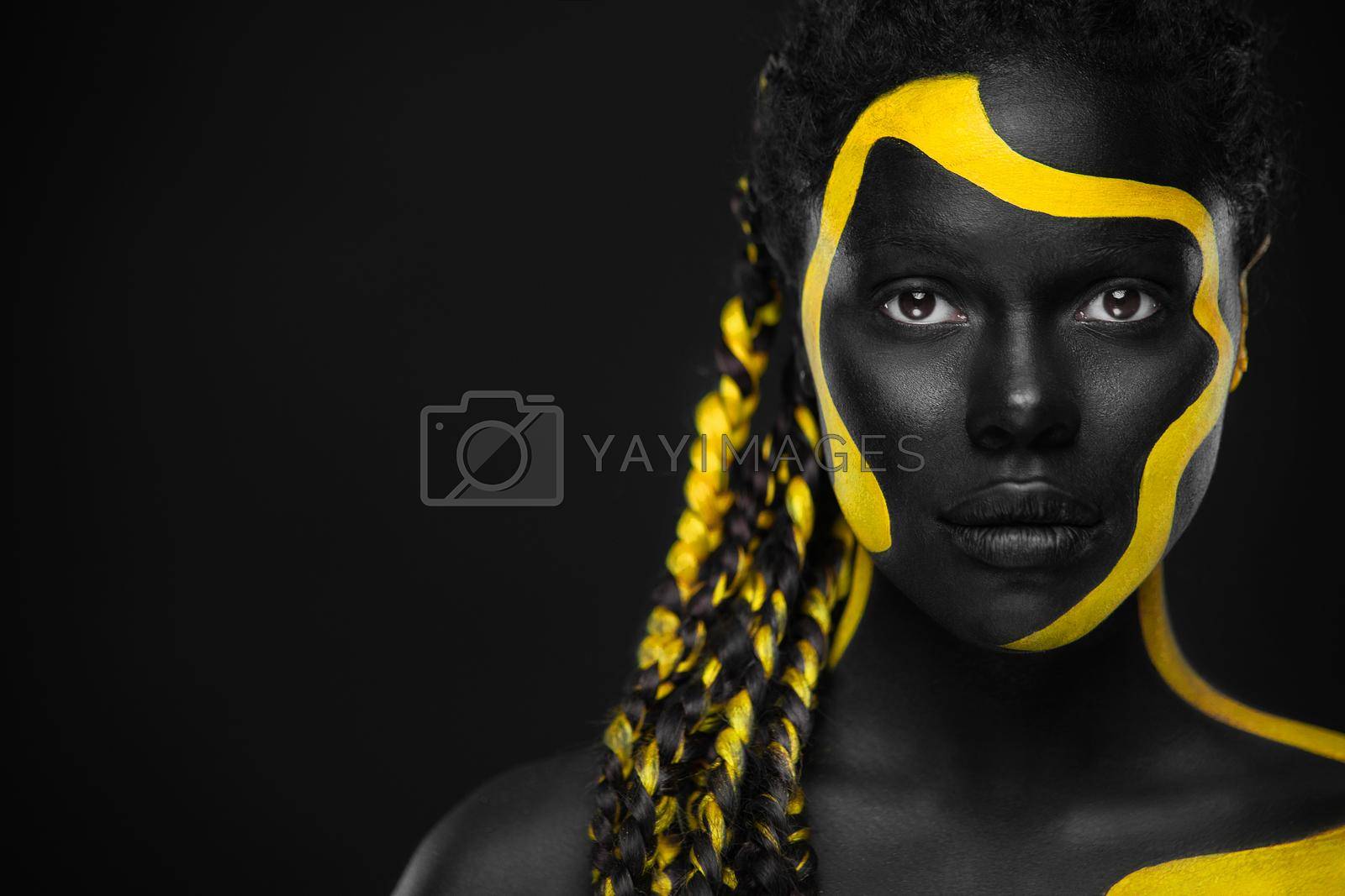 Yellow and black body paint. Woman with face art. Young girl with