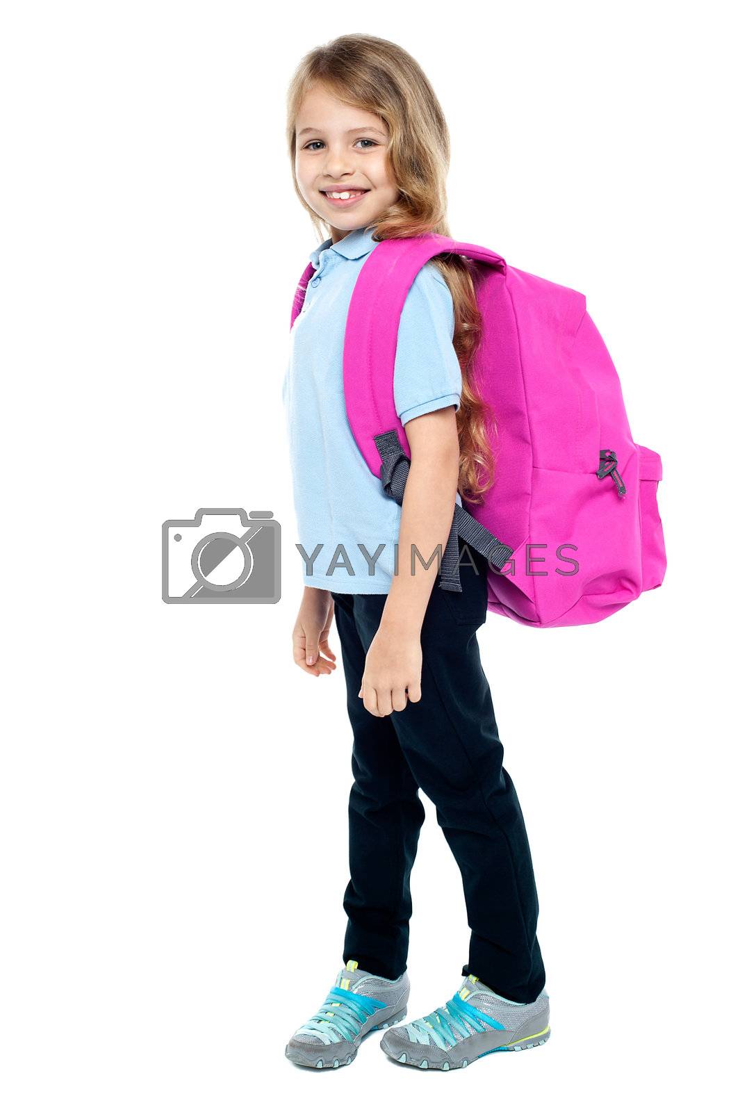 Happy little girl carrying school bag by stockyimages Vectors